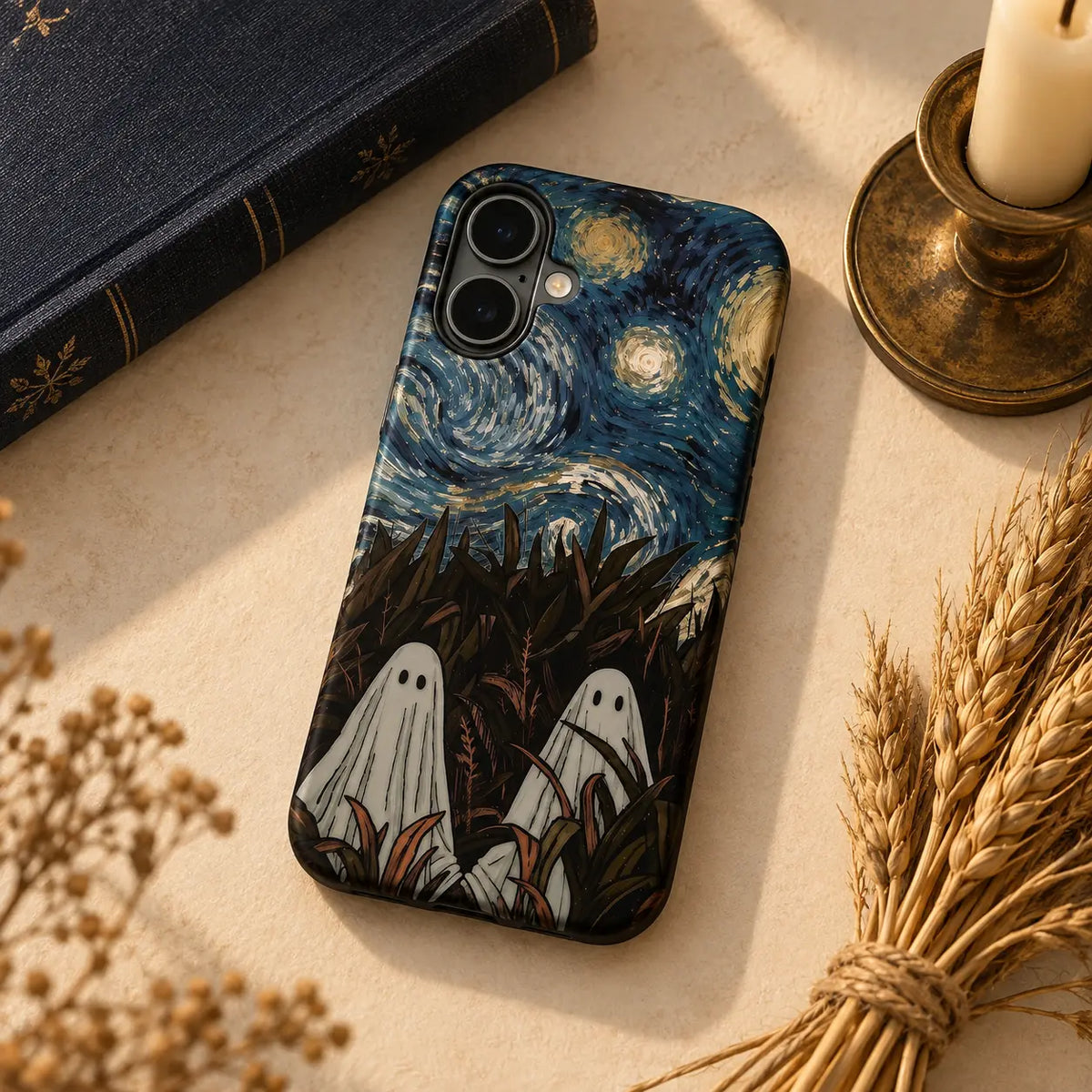 1. Ghosts Under the Wheat Ears phone case styled with dried wheat, a navy book and candle