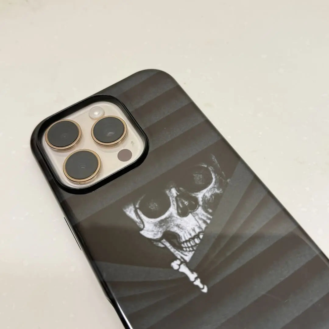 This Halloween phone case features a vintage collage of classic elements like pumpkins, black cats, and skeletons, adding a unique festive vibe.