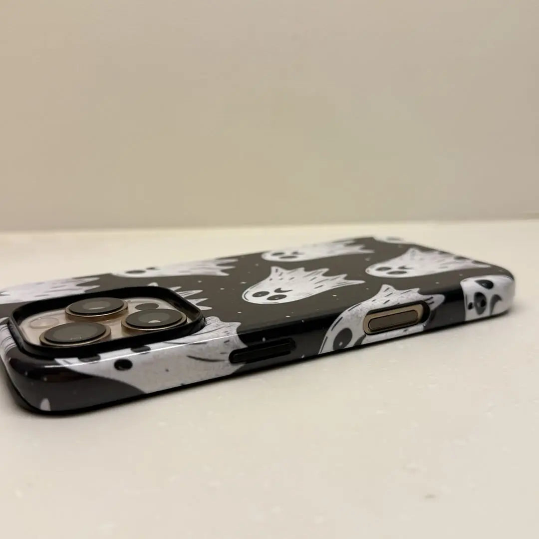 This Halloween phone case features a pattern of sad little ghosts on a black background, offering a simple yet mysterious touch of Halloween style.
