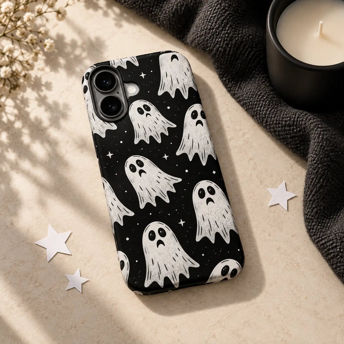 Little Ghost phone case styled with black fabric, candle and paper stars