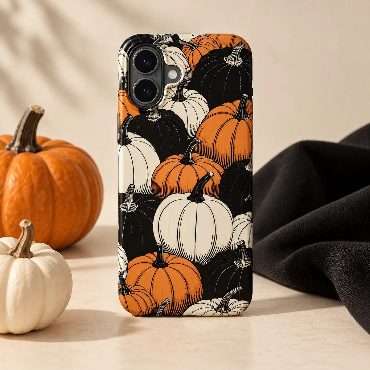 1. Pumpkin-pattern phone case displayed with orange and ivory pumpkins