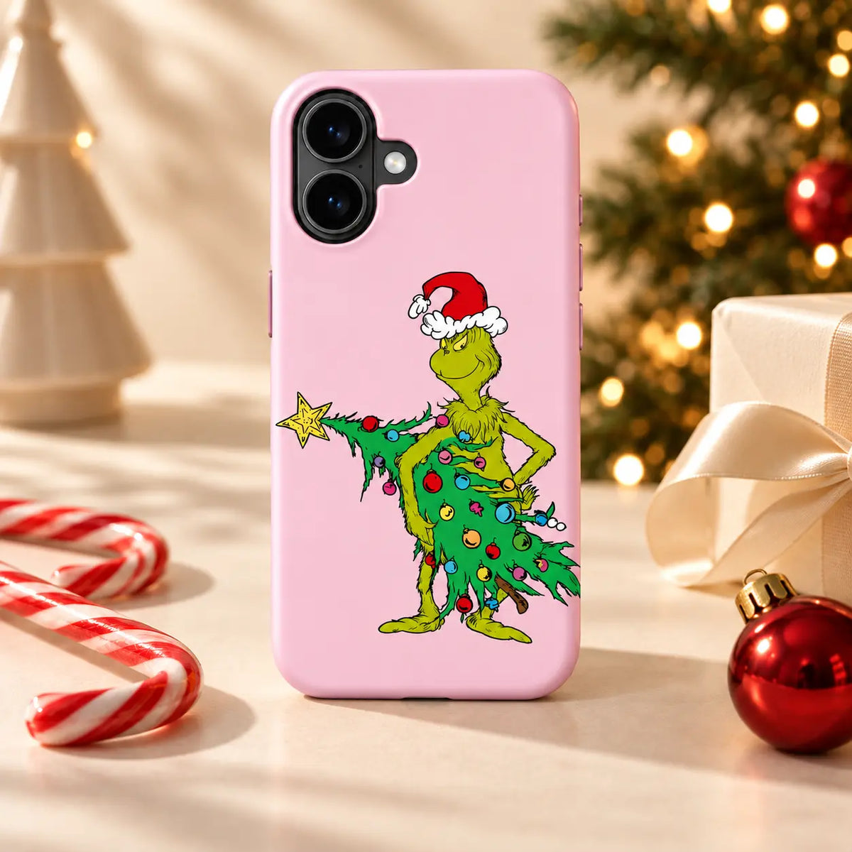 Pink Mean One Christmas Tree phone case in a warm holiday tabletop setting