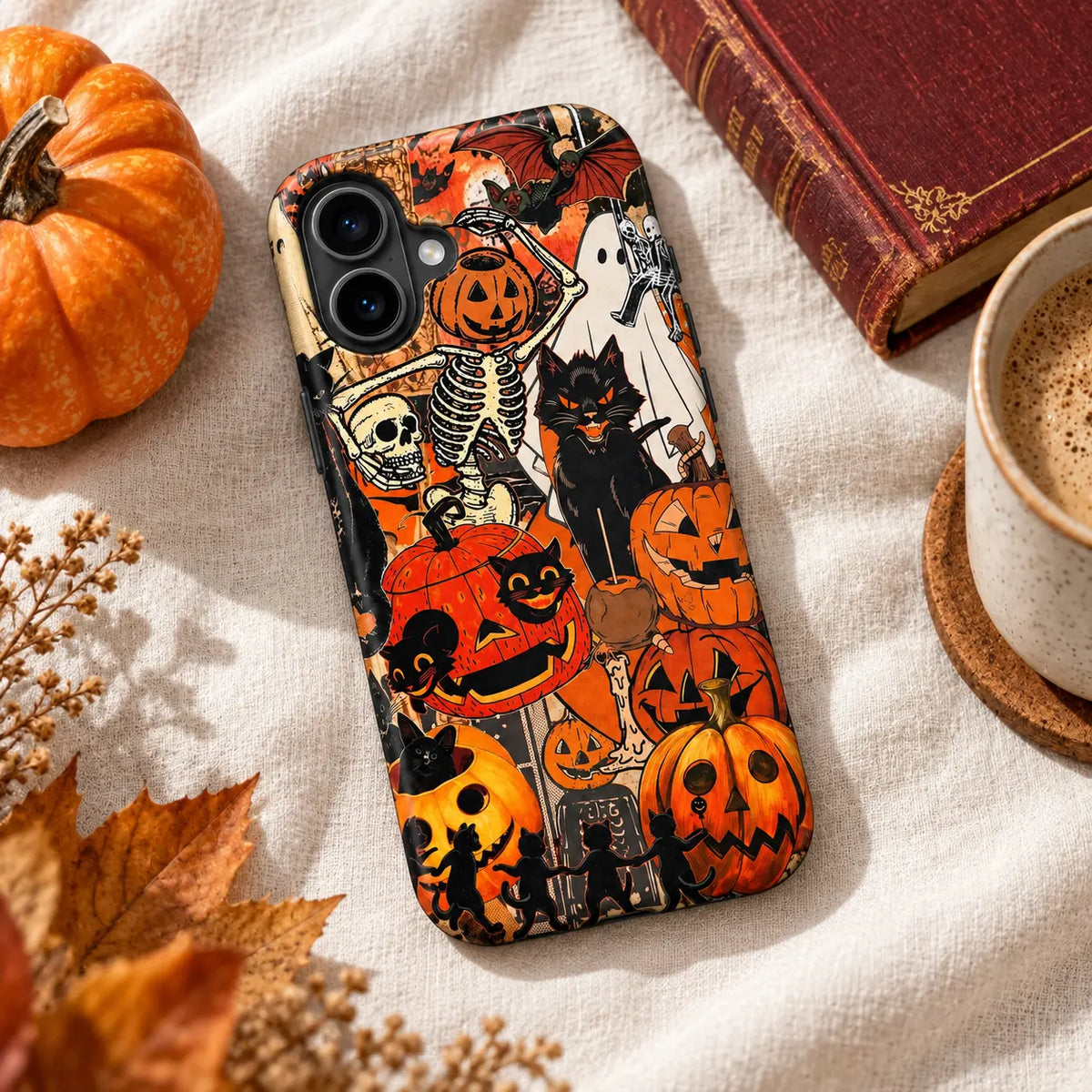 Black cat pumpkin phone case displayed with autumn decorations