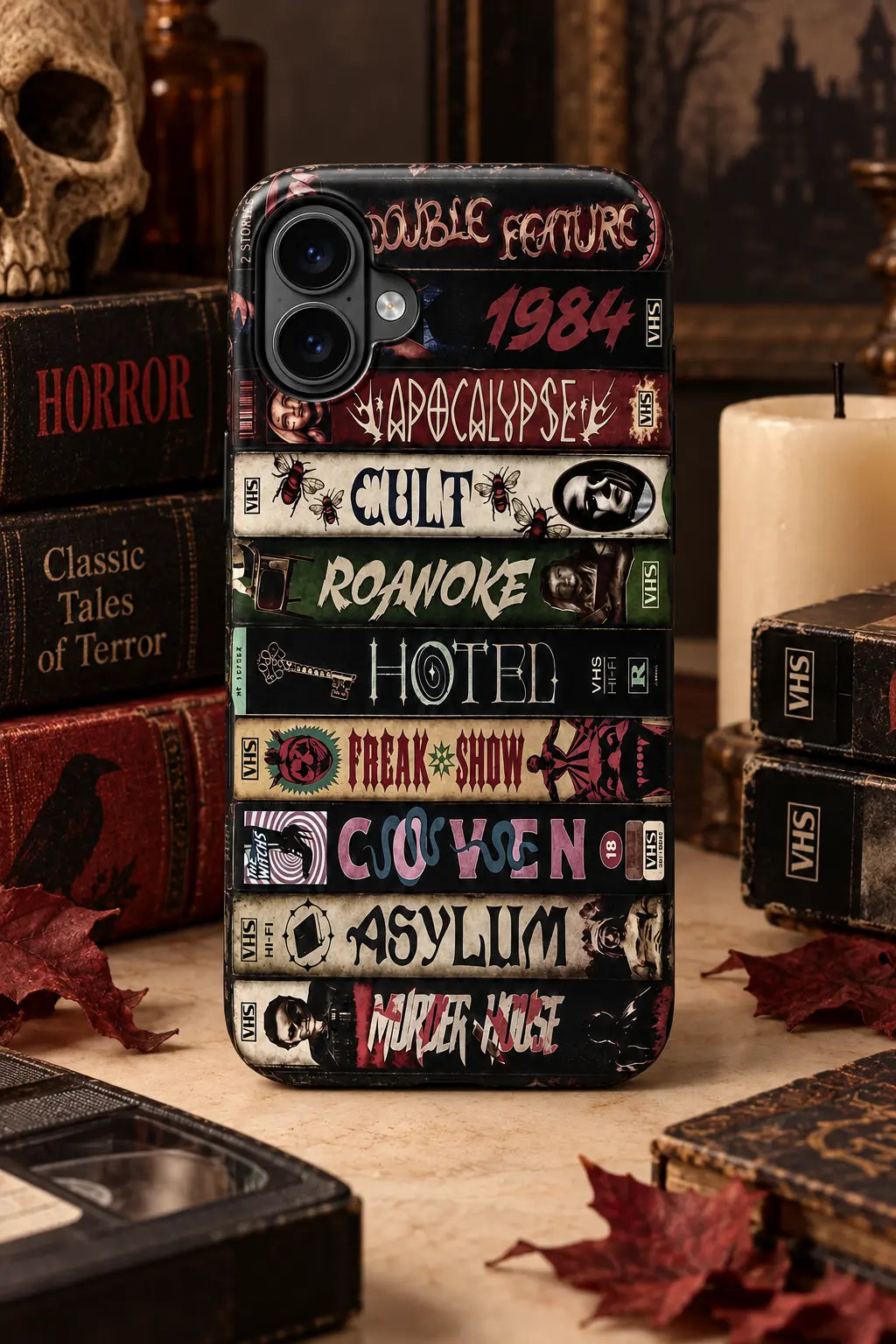 Vintage horror VHS book spine phone case displayed in a Halloween reading-table setting