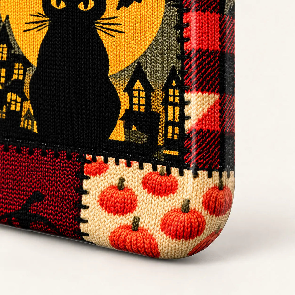 Rounded lower corner showing pumpkin and plaid artwork extending over the case edge.