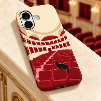 iPhone case on an ivory ledge with theater seating behind; Black cat among red theater seats with cream balconies