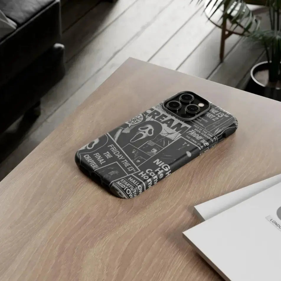 This Halloween phone case features a black and white newspaper-style collage of classic horror movie elements, offering a subtle yet unique accessory.
