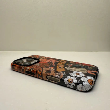 This Halloween phone case features a vintage collage of various horror elements, creating a unique and trendy accessory for the spooky season.